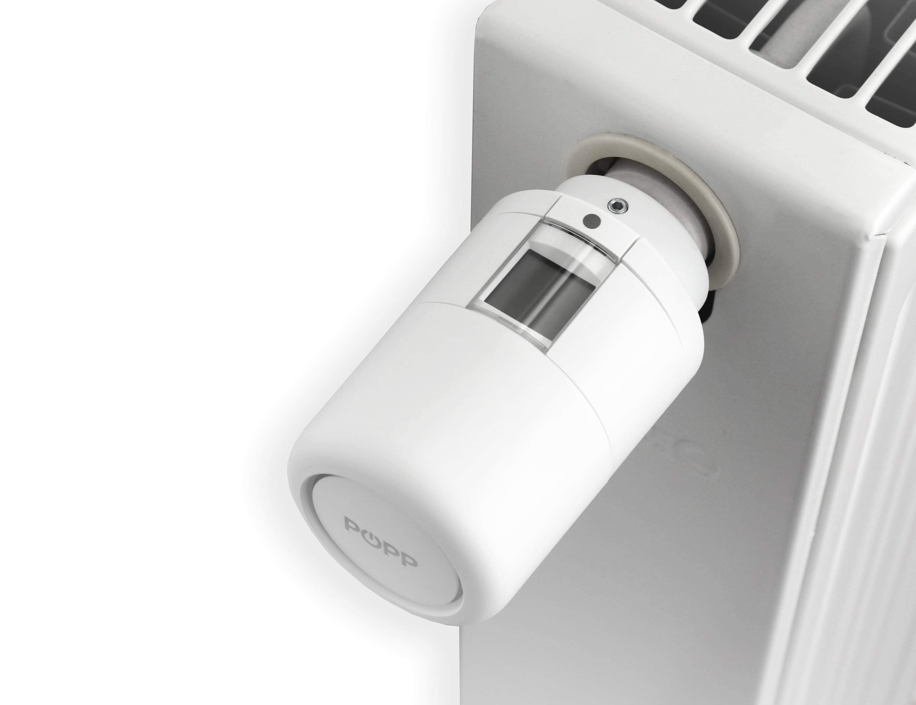 Ein weißes Heizkörperthermostat, montiert an einem Heizkörper, reguliert die Raumtemperatur einstellbar.