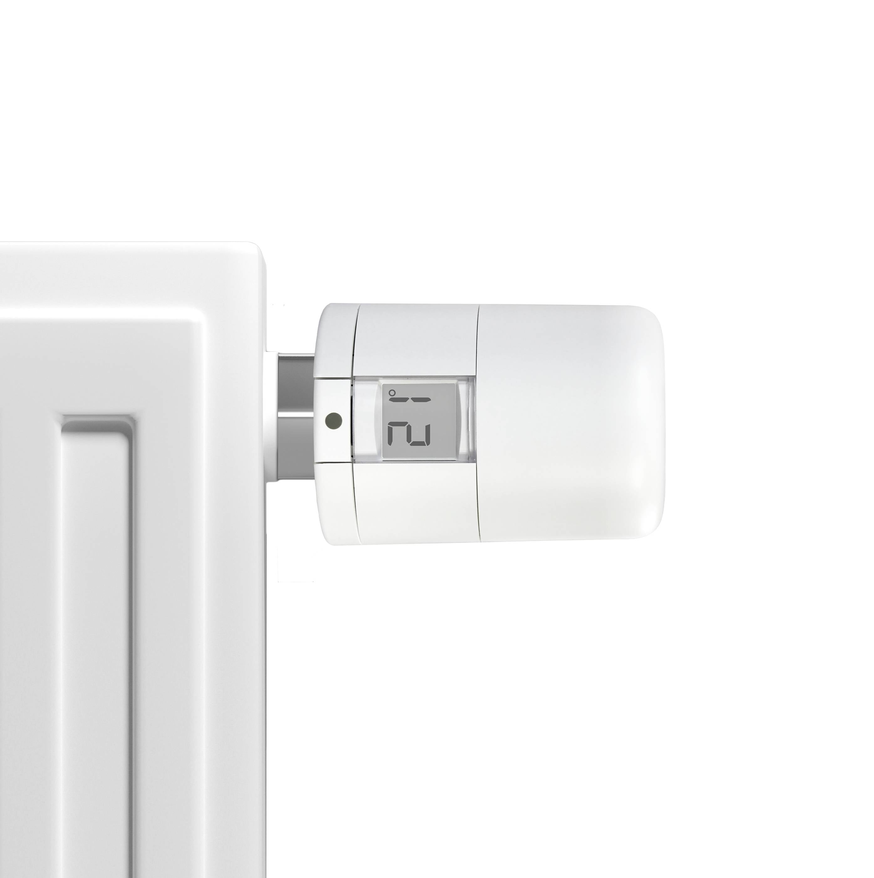 Ein weißer Heizkörper mit einem digitalen Thermostat, das die Temperaturregelung anzeigt.