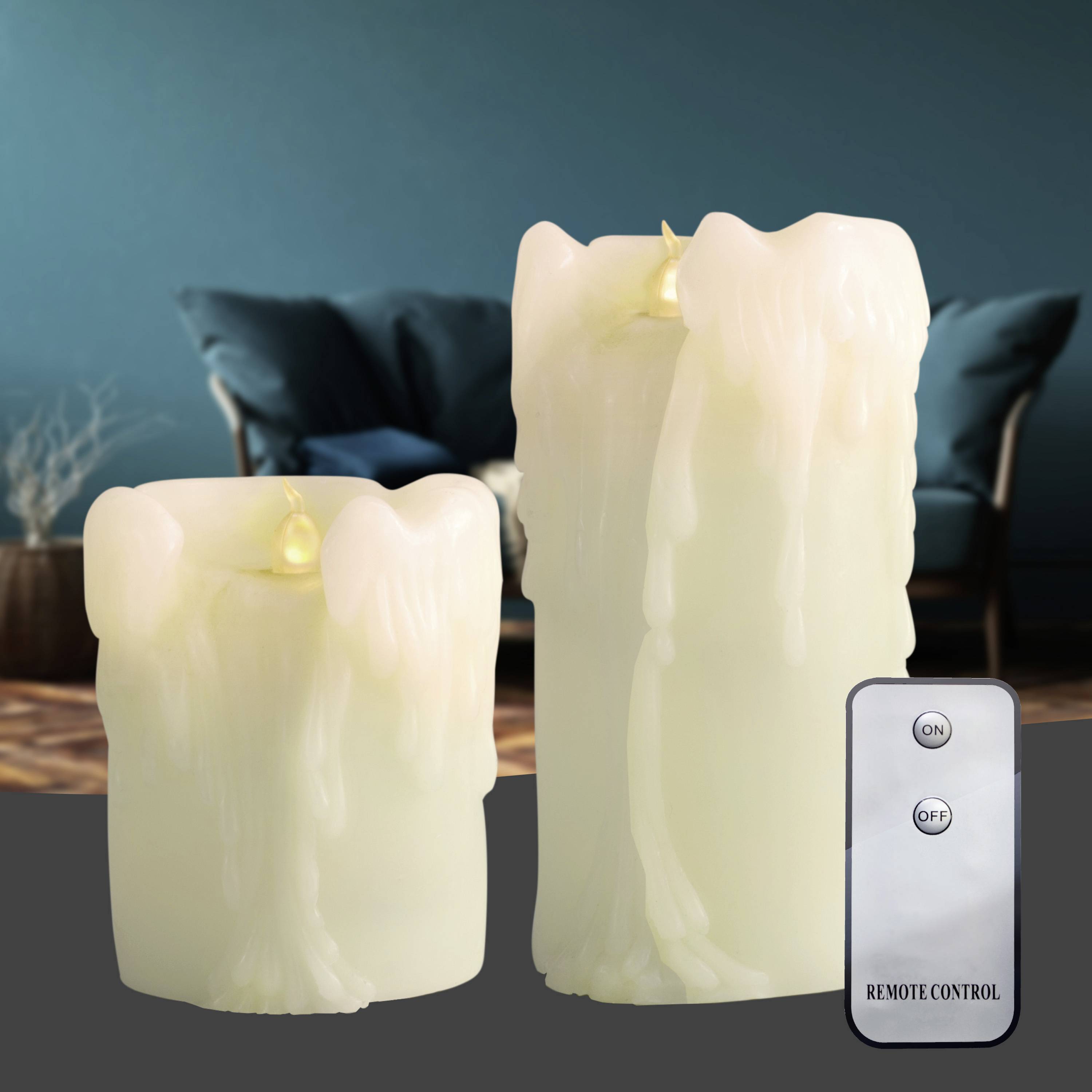 Zwei weiße Kerzen aus Wachs mit LED-Flammen auf einem dunklen Tisch, dahinter ein Sofa. Eine Fernbedienung zeigt 'ON' und 'OFF'.