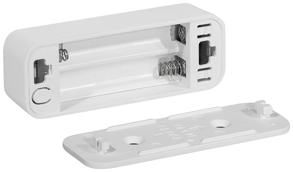 Ein offenes Batteriefach für zwei AA-Batterien mit abgenommener Abdeckung, die daneben liegt.