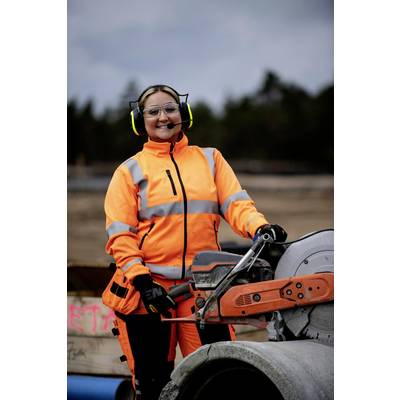 Arbeiterin in orangefarbenem Sicherheitsanzug verwendet eine Kreissäge, um Rohre auf einer Baustelle zu schneiden.