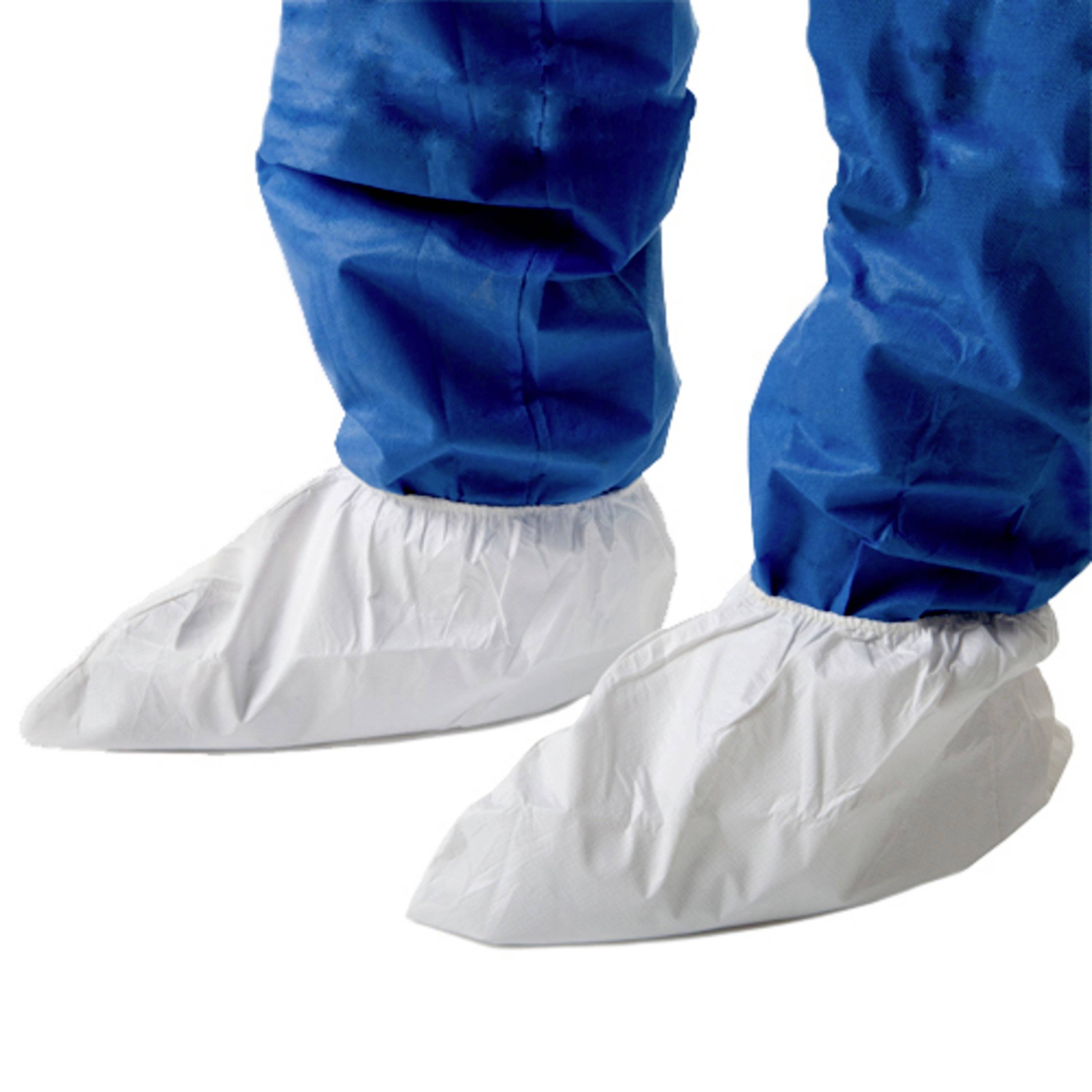 Zwei Füße in weißen Überschuhen und blauen Schutzanzugshosen. Geeignet für sterile oder saubere Umgebungen.