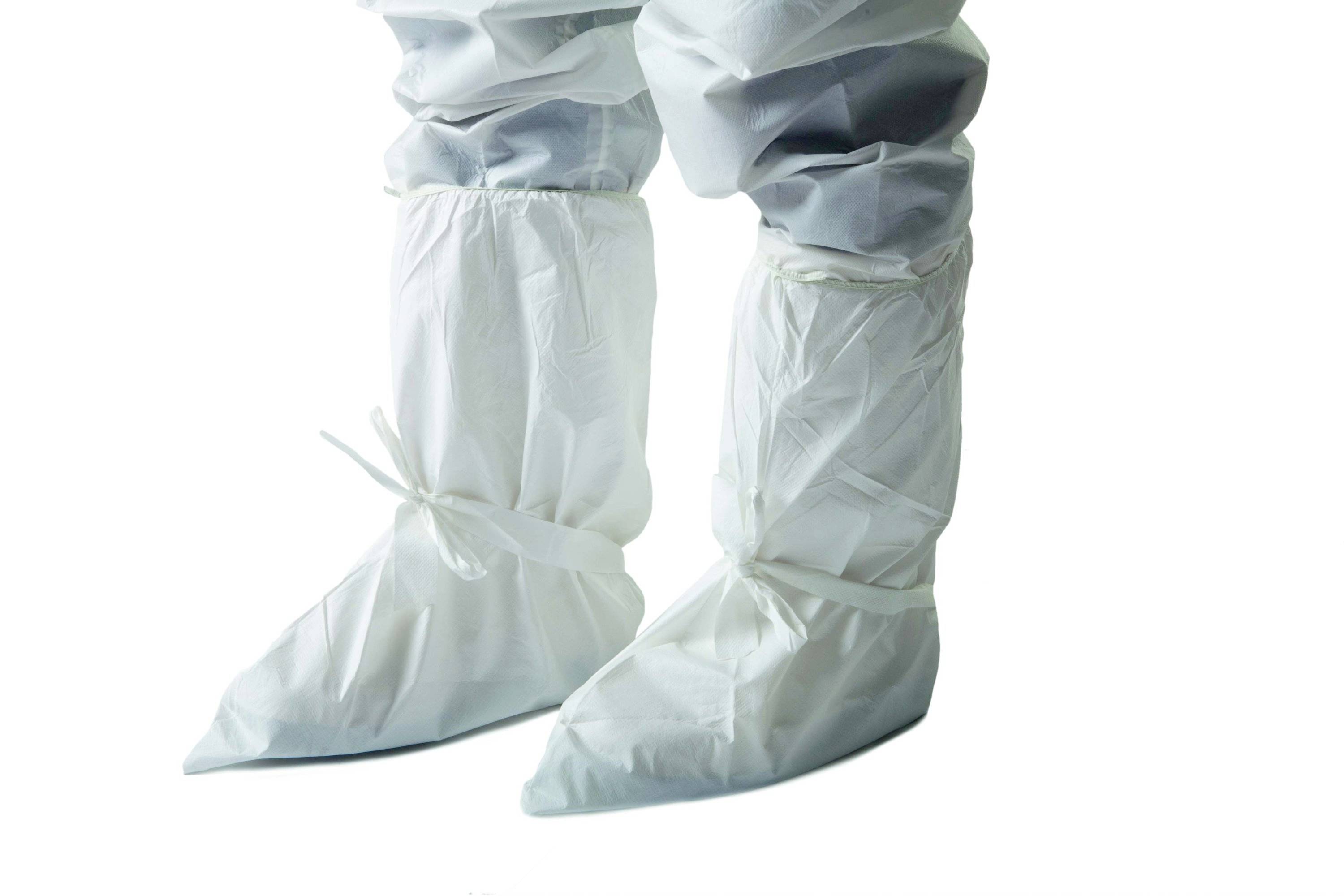 Person in weißen Schutzanzügen mit Überschuhen. Anzüge sind glatt und gegen chemische oder biologische Gefahren bestimmt.