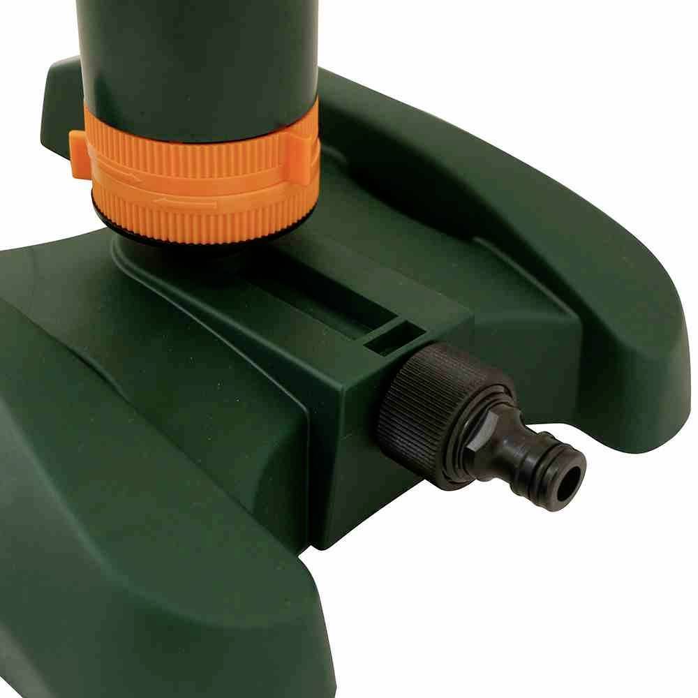 Grüner Gartensprenger mit orangefarbenem Ring und Wasseranschluss. Ideal für Bewässerung großer Rasenflächen.