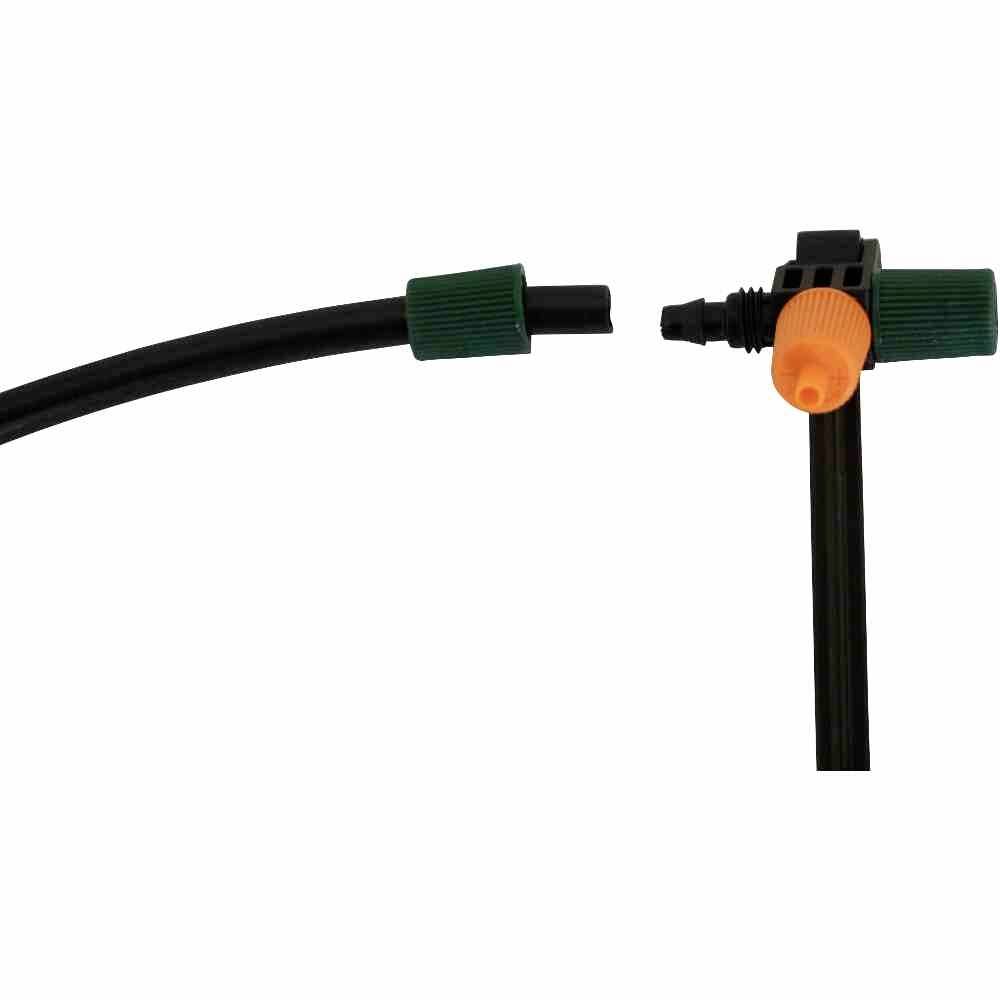 Schwarz-grüner Schlauch und Verbindungsstück mit orangefarbenem Detail, vermutlich Teil eines Gartenbewässerungssystems.