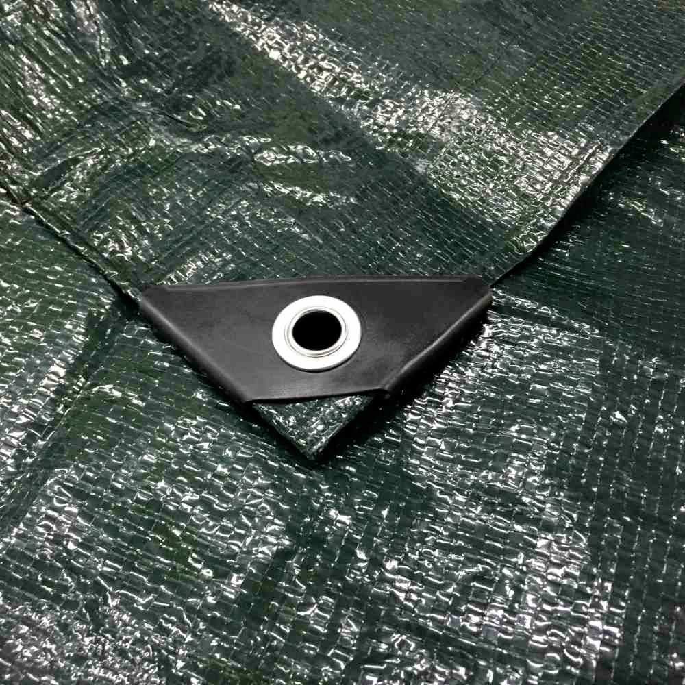 Eine grüne Plane mit Metallöse in der Ecke, geeignet zum Befestigen oder Abdecken von Gegenständen im Freien.