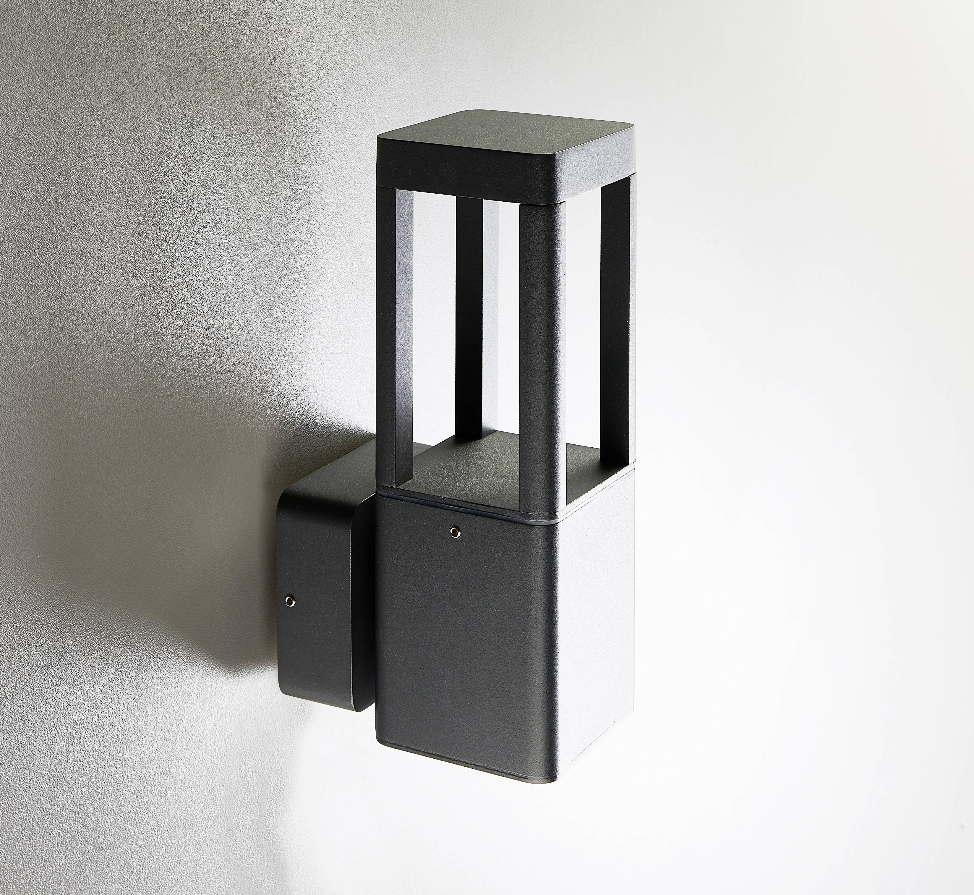Ein modernes, graues Wandleuchtendesign mit quadratischen Formen. Die Lampe ist strukturiert und in einem minimalistischen Stil gehalten.