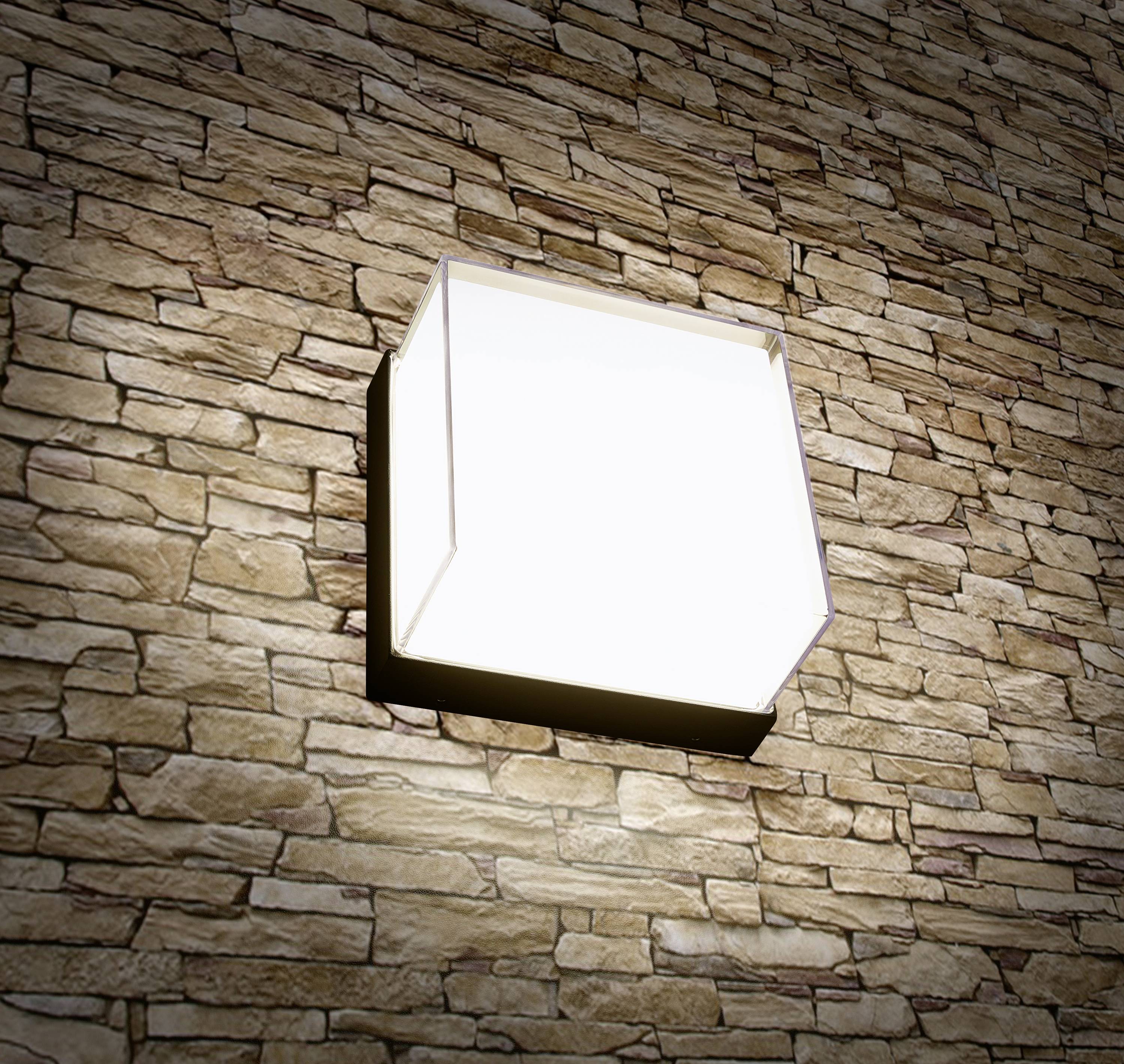Wandleuchte mit modernem Design leuchtet an einer Wand mit Ziegelsteinstruktur.