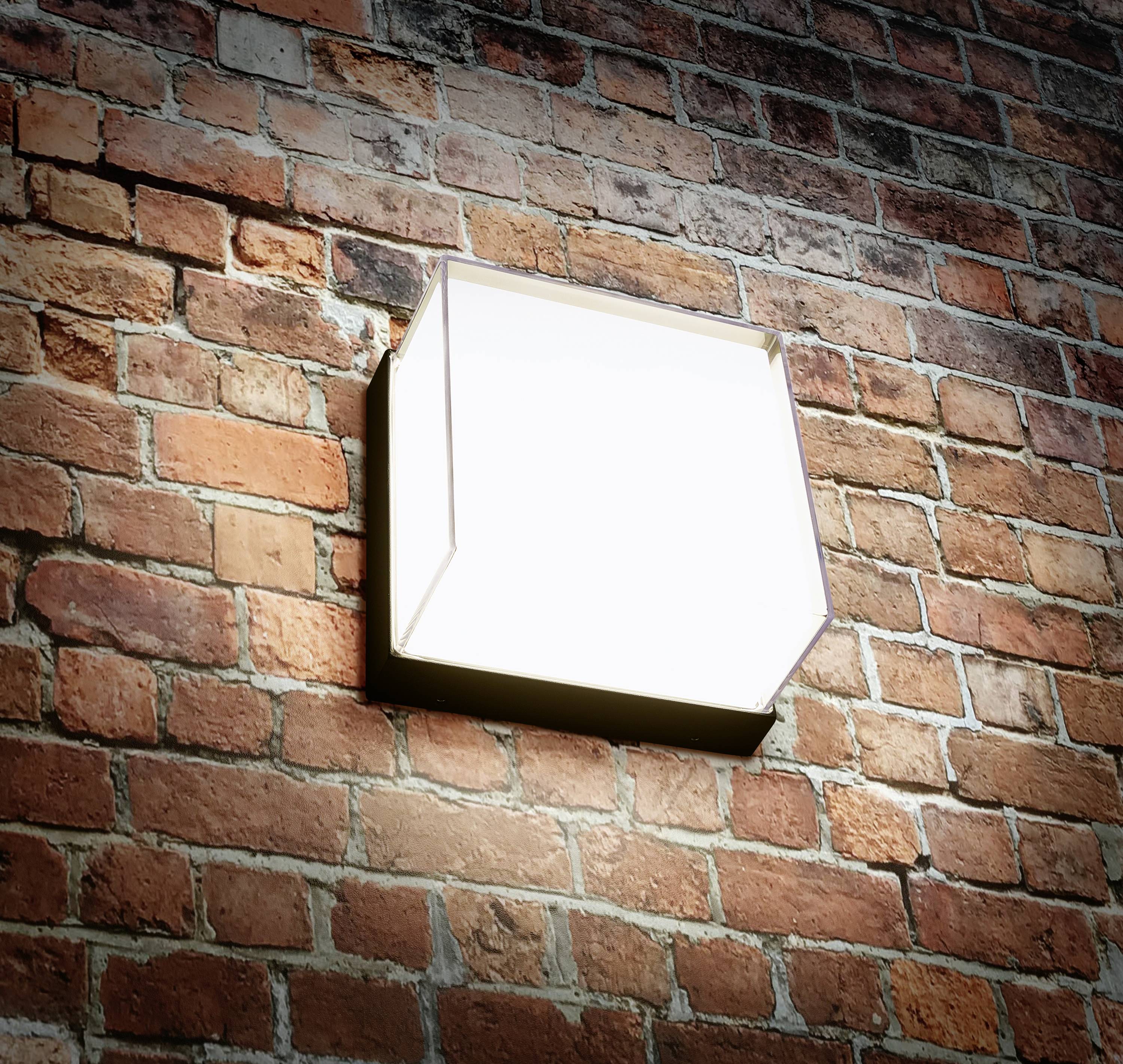 Eine leuchtende Wandlampe ist an einer Ziegelmauer befestigt und strahlt helles Licht aus. Die Mauer hat eine rötlich-braune Farbe.
