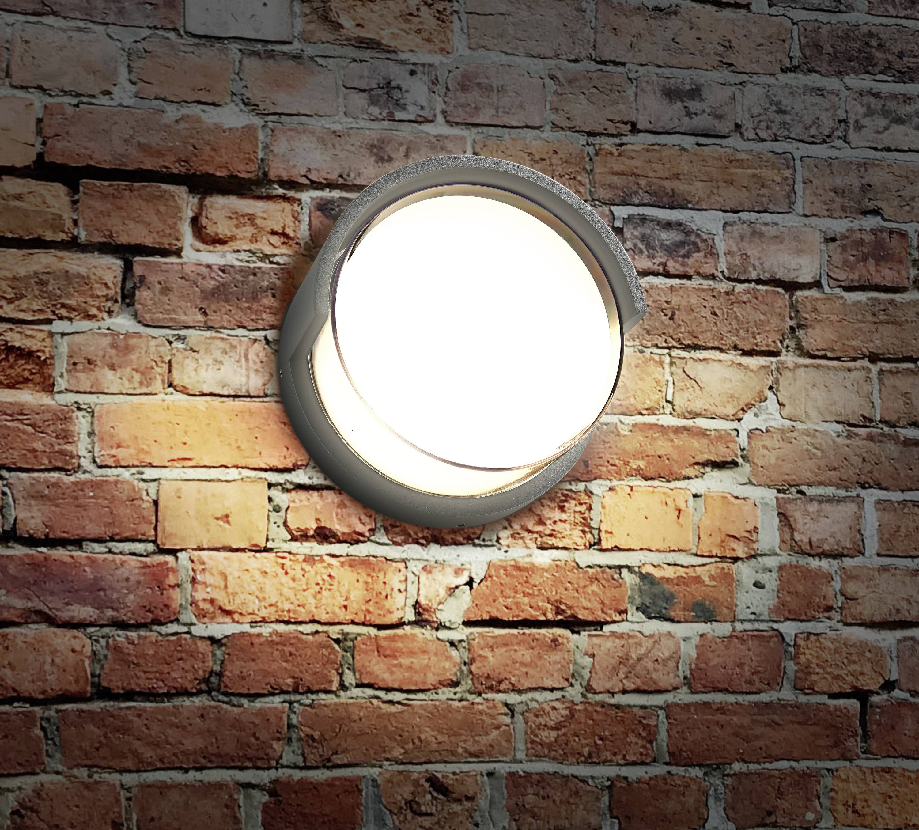 Eine leuchtende, runde Außenlampe an einer roten Ziegelmauer, die warmes Licht abstrahlt.