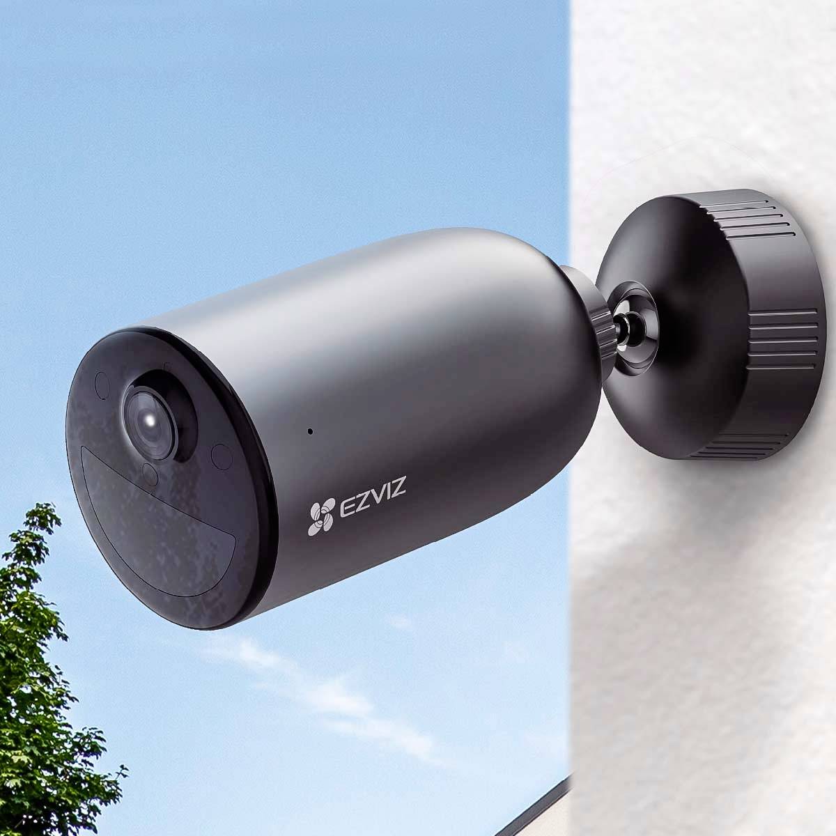 Überwachungskamera mit Wandhalterung im Freien, zeigt blauen Himmel im Hintergrund.