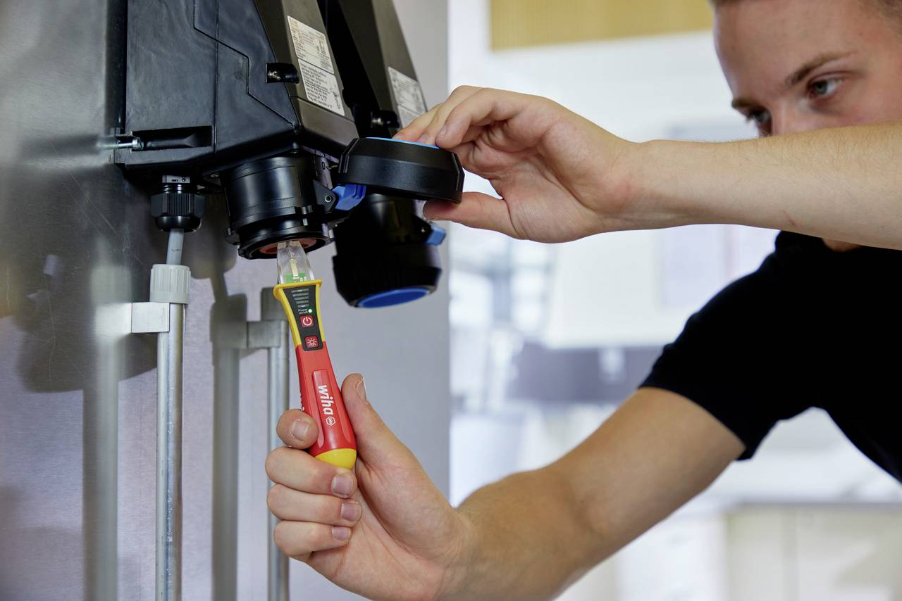 Eine Person testet mit einem digitalen Gerät die Qualität einer Substanz in einem Laborumfeld.