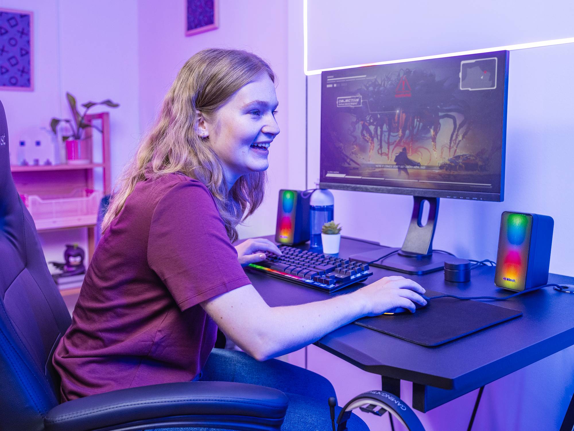 Eine Person sitzt an einem Schreibtisch und spielt ein Videospiel auf einem Computer. Sie schaut aufmerksam auf den Bildschirm.