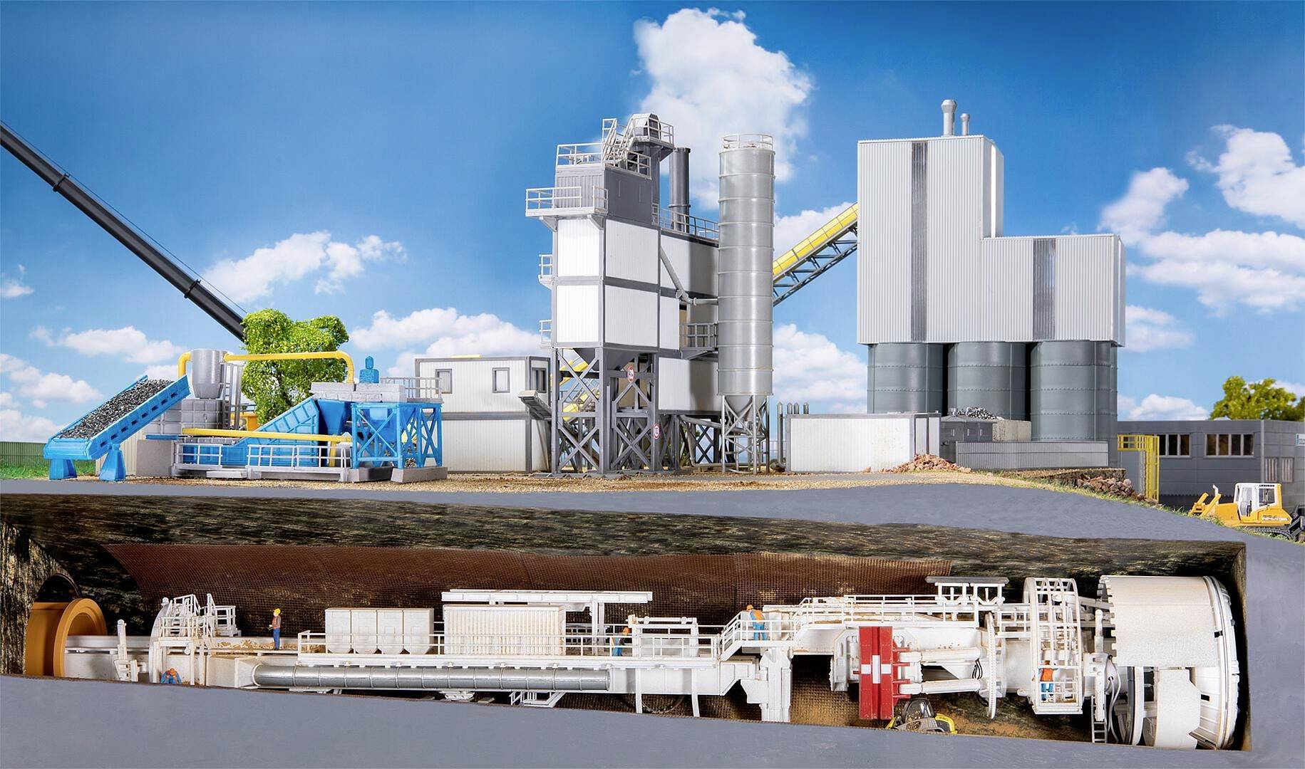 Eine Schnittdarstellung zeigt eine Tunnelbohrmaschine unter einer modernen Fabrikanlage. Im Hintergrund blauer Himmel mit Wolken.