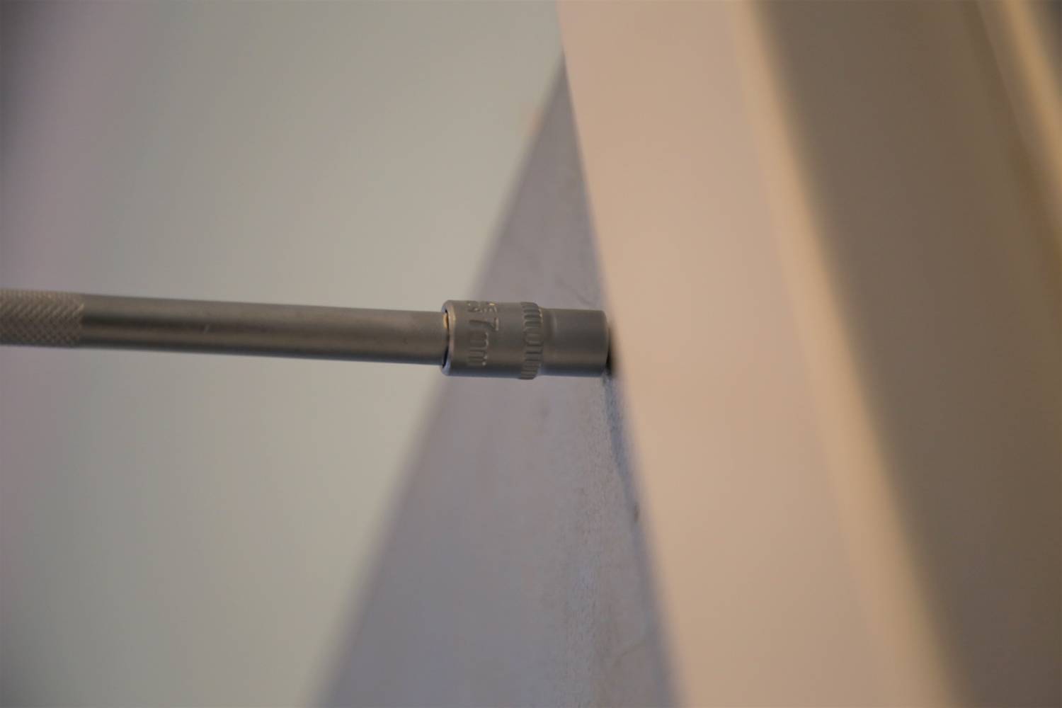 Ein Schraubenzieher wird benutzt, um eine Schraube in eine Wand oder Oberfläche zu drehen.
