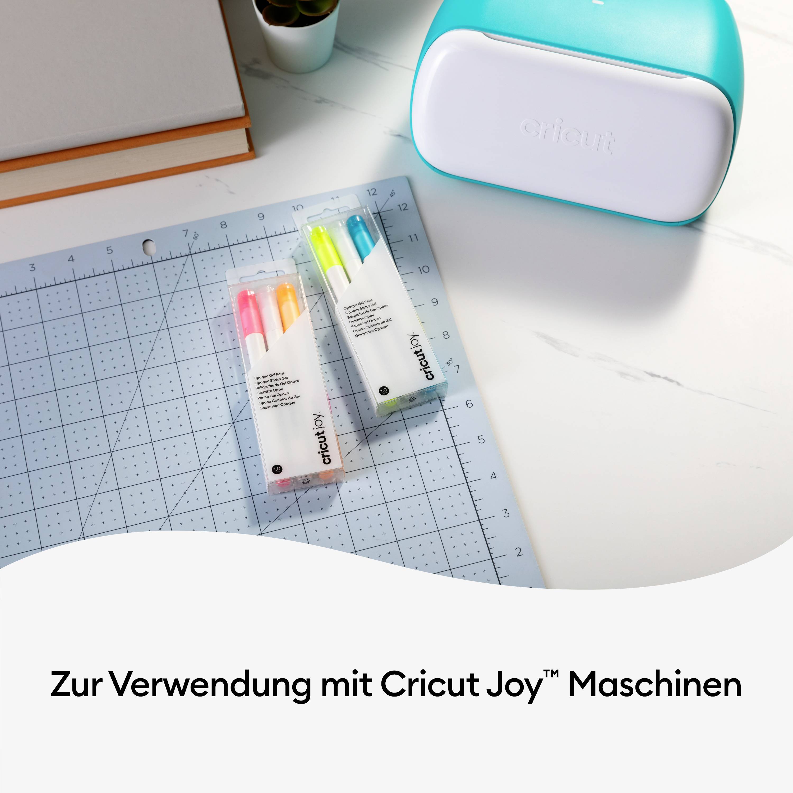 'Cricut Joy Maschine und Zubehör auf einem Schreibtisch mit Schneidematte, Filzstifte in Gelb, Blau und Grün.'