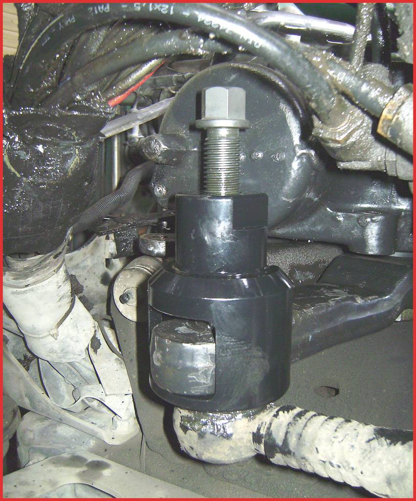 Ein hydraulisches Abziehwerkzeug entfernt einen Radlagerflansch von einem Fahrzeug. Der Mechanismus ist klar sichtbar angebracht.