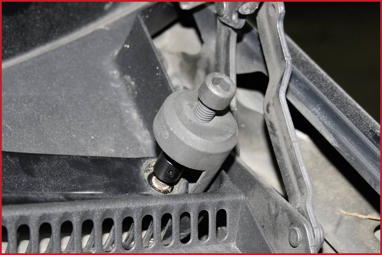 Nahaufnahme eines Teils eines Schraubenschlüssels im Einsatz an einer mechanischen Vorrichtung. Fokus auf Schraubverbindung und Werkzeug.