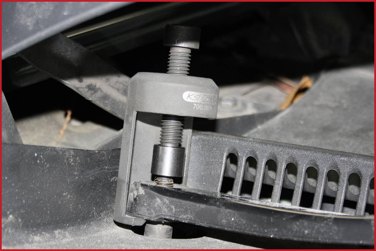 'Nahaufnahme eines Werkzeugs zur Montage eines Keilriemens. Das Werkzeug spannt den Riemen, um die Installation zu erleichtern.'