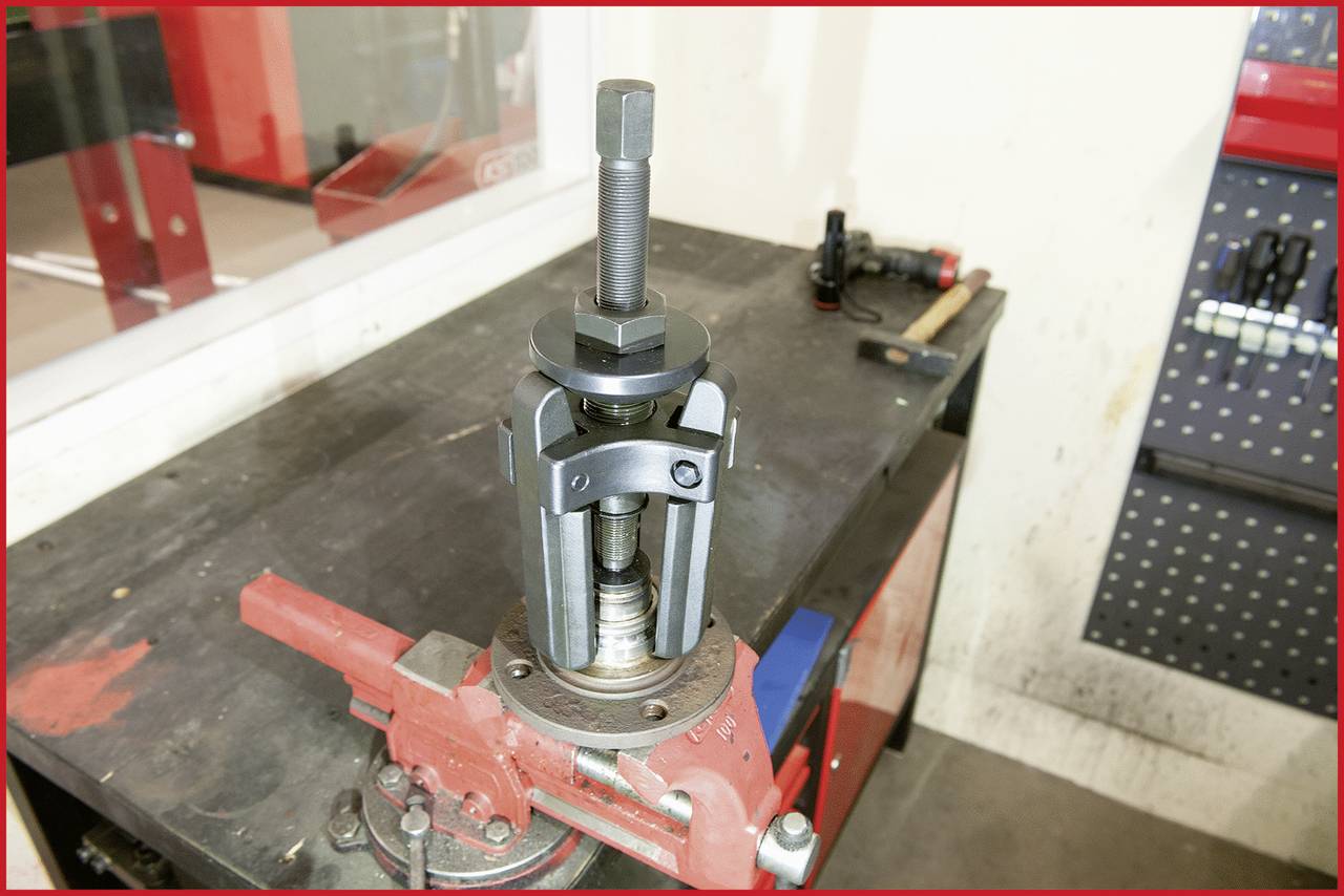 Ein mechanisches Werkzeug, das auf einer Werkbank in einer Werkstatt befestigt ist. Es wird verwendet, um Teile von Maschinen zu entfernen.