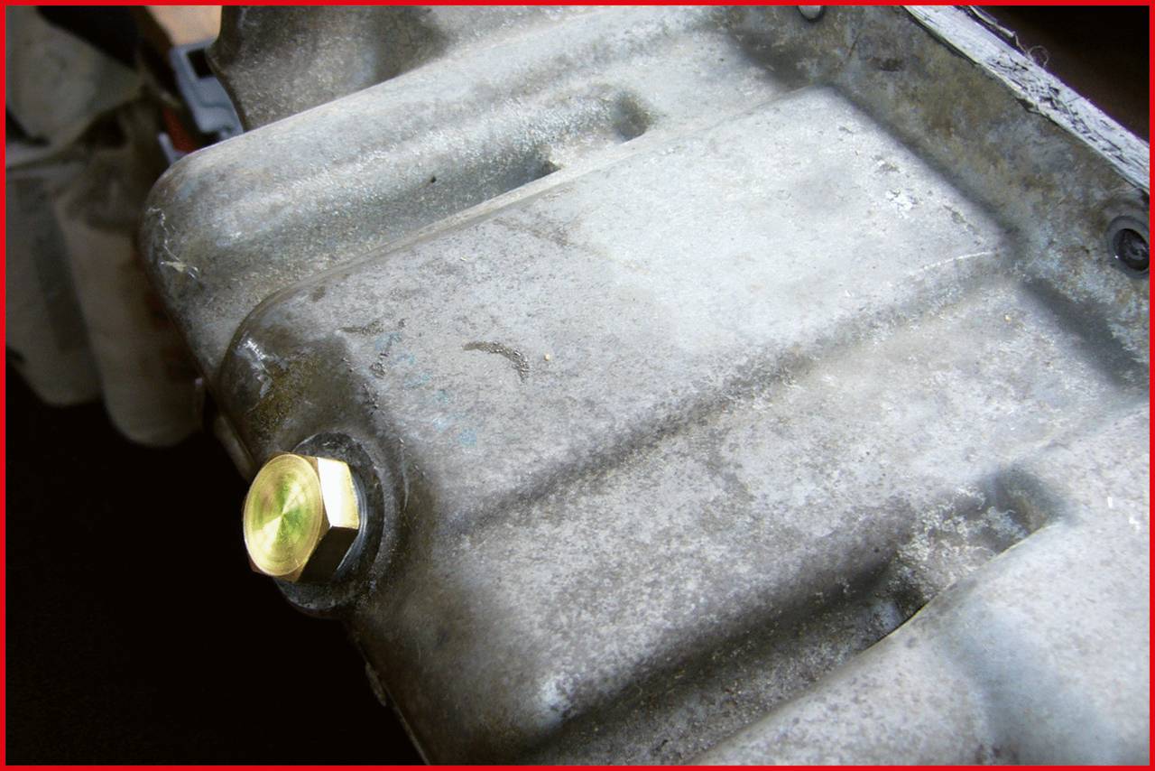 Nahaufnahme eines Metallgehäuses mit einer gelblichen Schraube darauf. Das Gehäuse zeigt Gebrauchsspuren.