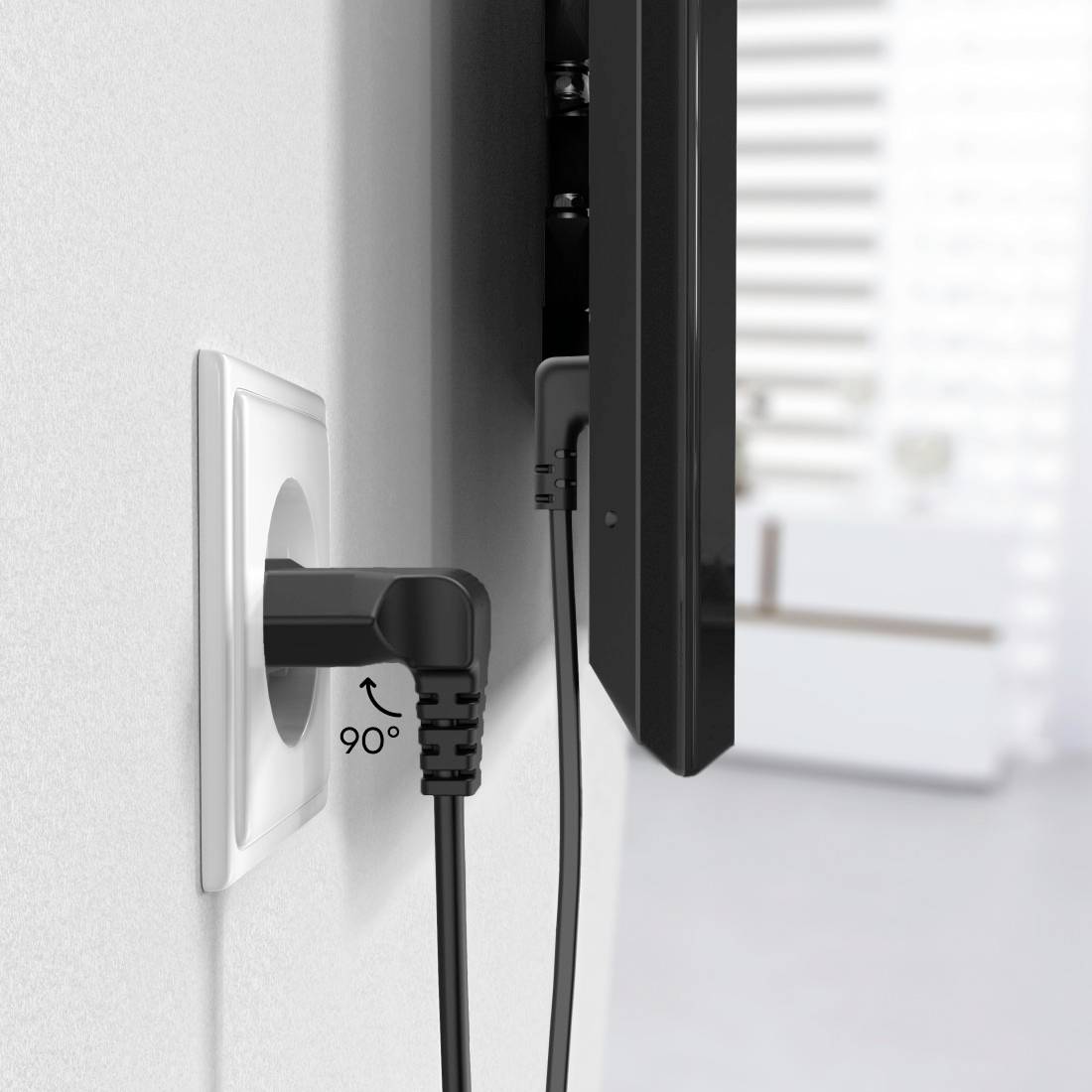 Ein Fernsehkabel mit angewinkeltem Stecker ist in eine Wandsteckdose eingesteckt, um Platz hinter dem Fernseher zu sparen.