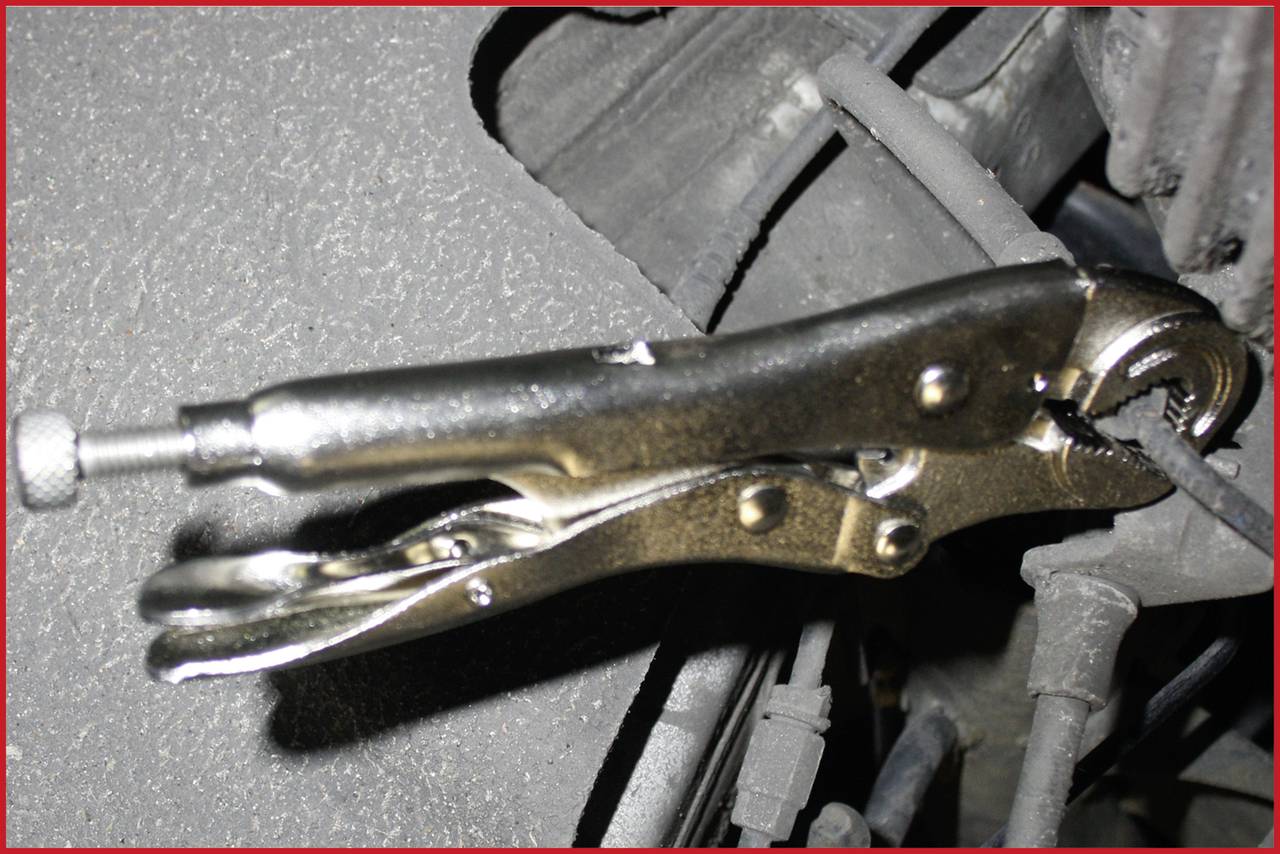 'Feststellzange hält eine Metallstange, verwendet für Reparatur oder Befestigung.'