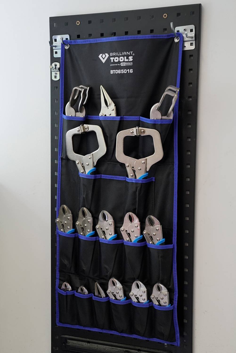 Werkzeugwand mit schwarzen Halterungen, bestückt mit verschiedenen Zangen in Silber. Oben steht 'Brilliant Tools'.