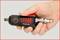 Hand, die ein schwarzes KS Tools Druckluftwerkzeug mit roter Aufschrift 'Xtreme light' hält. Es ist ein kompaktes Gerät mit Anschluss.