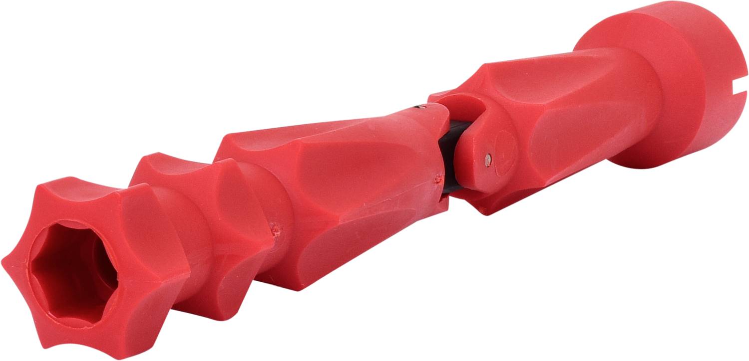 Ein rotes, plastisches Objekt mit facettenreicher, wellenförmiger Struktur, ähnlich einem mechanischen Bauteil oder Werkzeug.