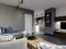Wohnzimmer mit grauem Sofa, Holztisch und modernem TV-Schrank; im Hintergrund ist eine offene Küche sichtbar.