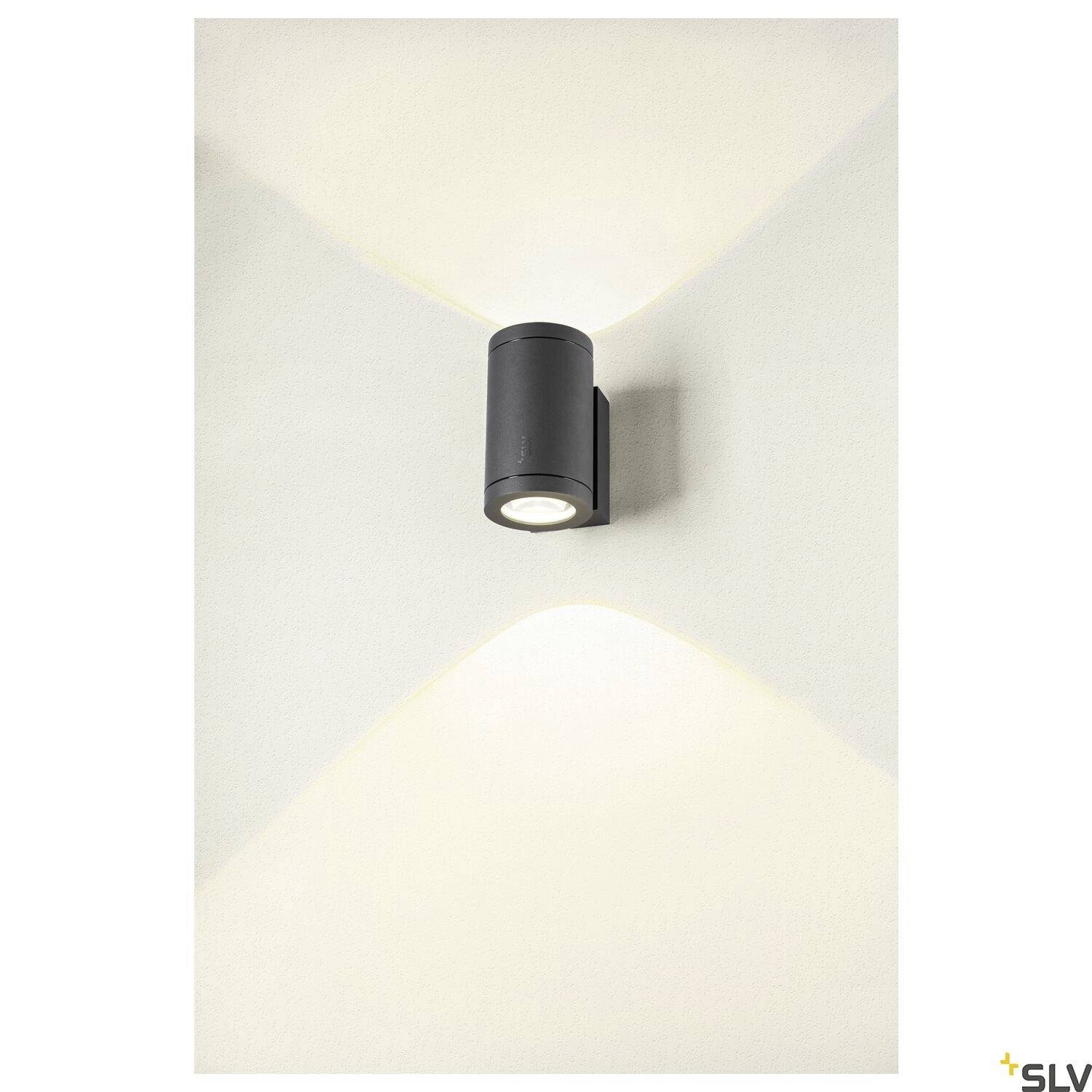 Eine schwarze zylindrische Wandlampe strahlt Licht nach oben und unten und erzeugt ein elegantes, gerichtetes Lichtmuster.