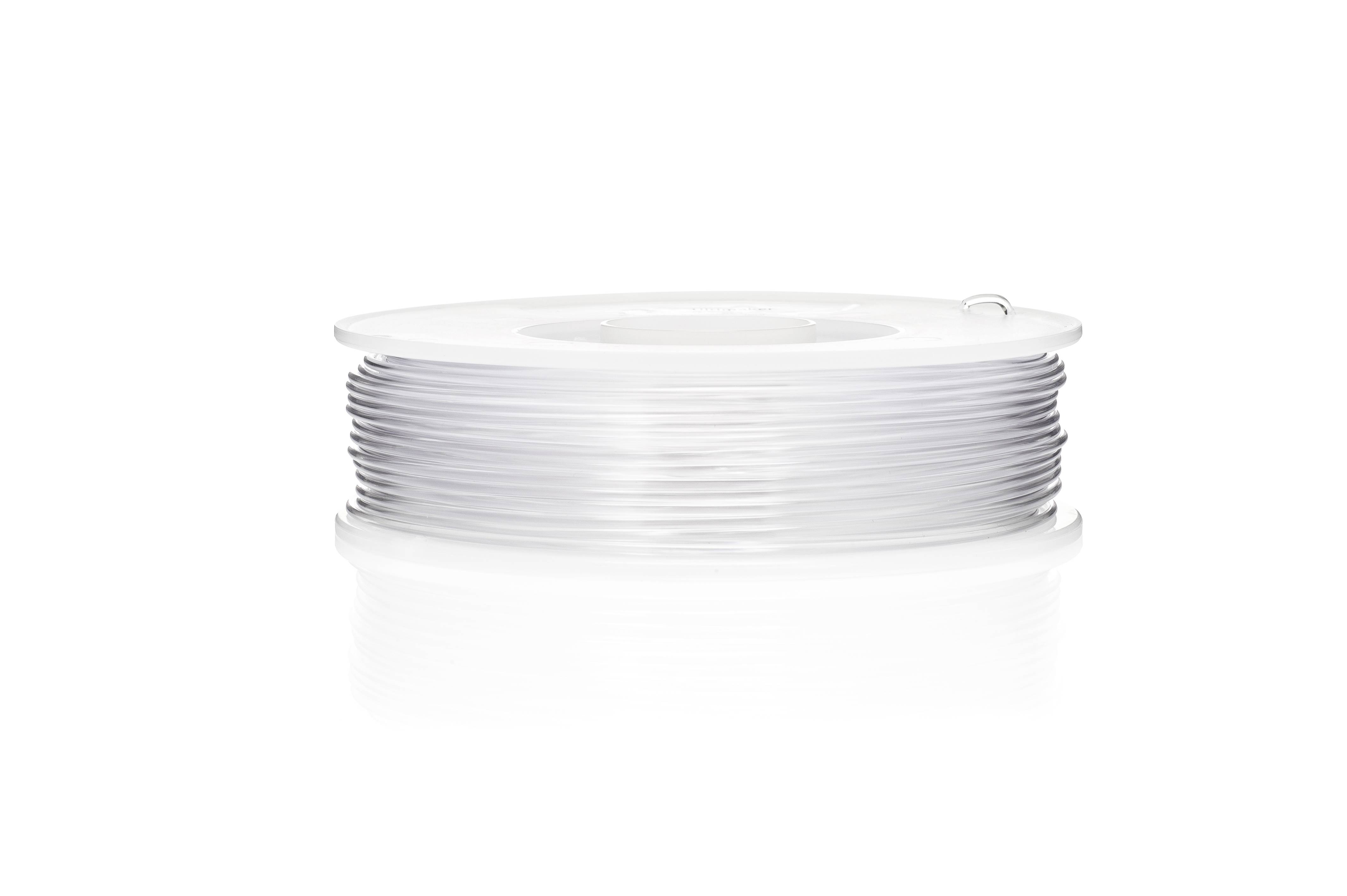 Eine weiße Spule mit transparentem Filament, auf einer glänzenden Oberfläche liegend.