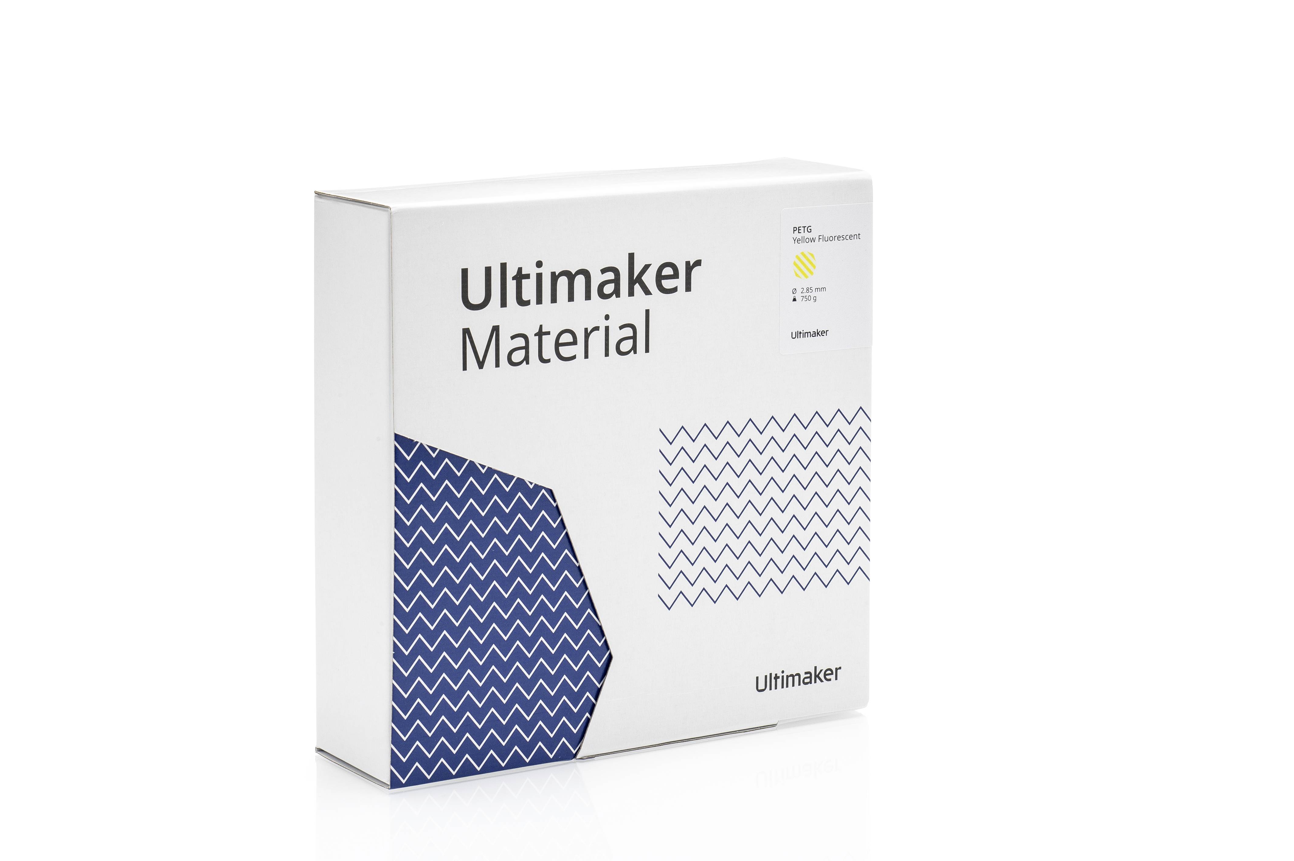 Weiße Verpackungsbox mit der Aufschrift 'Ultimaker Material'. Enthält Muster aus blauen Zickzack-Linien und eine gelbe Logo-Grafik.