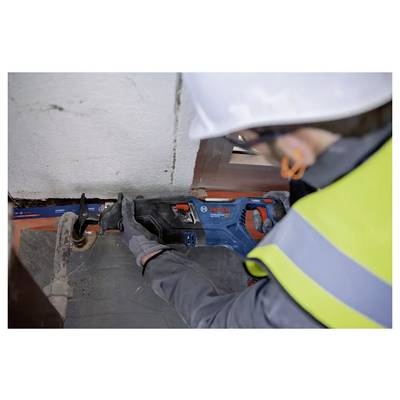 Ein Bauarbeiter mit Sicherheitsausrüstung verwendet eine Bosch-Reciprosäge, um an einer Baustelle ein Rohr zu durchtrennen.