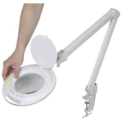 Eine Hand öffnet eine weiße Lupenleuchte an einem flexiblen Arm, die an einem Tisch befestigt ist.