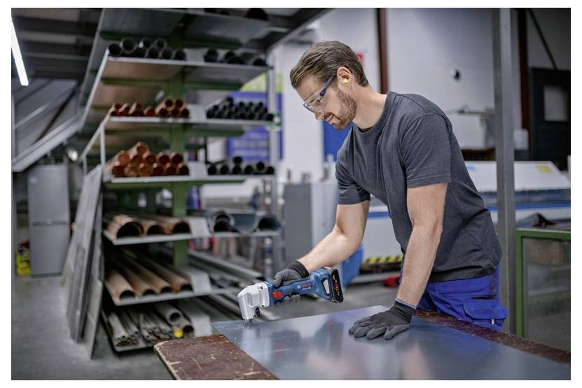 Techniker benutzt einen Bosch-Akkubohrer, um ein Metallgeräteregal in einer Werkstatt zusammenzubauen.