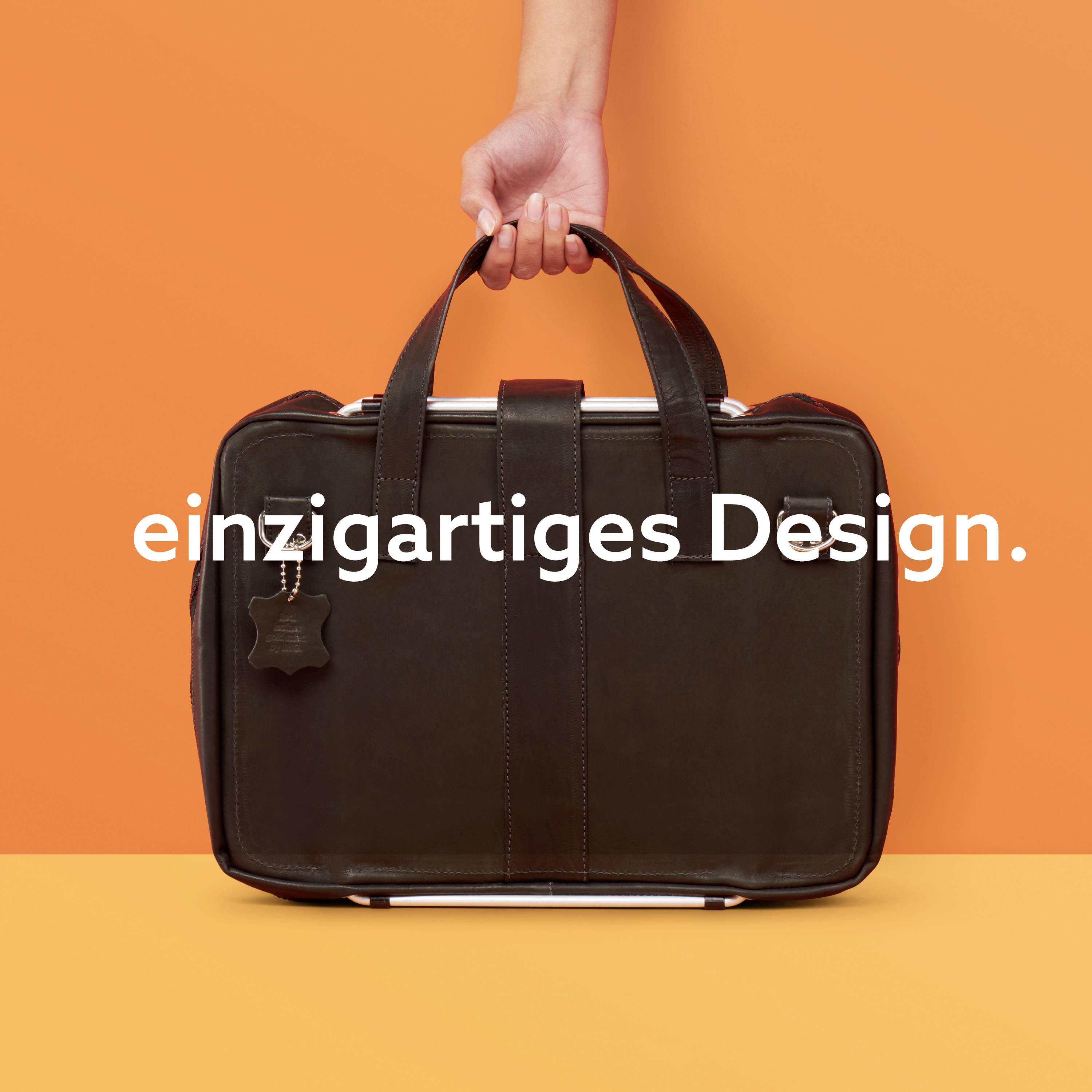 Ein Lederrucksack vor einem orangefarbenen Hintergrund. Eine Hand greift nach dem Griff. Text auf dem Bild: 'einzigartiges Design.'