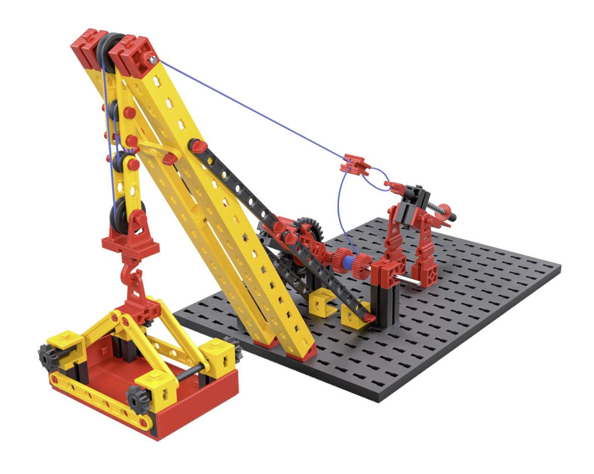 Ein bunter Modellbaukran aus Plastikbausteinen steht auf einer schwarzen Lochplatte. Der Kran hebt ein kleines, gelbes Objekt an.