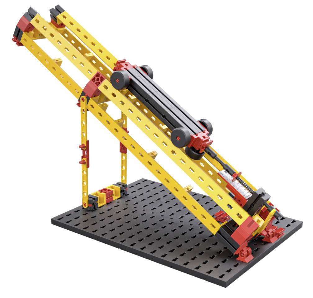 Ein gelbes und rotes Modell einer schrägen Rampe auf einem schwarzen Untergrund, gebaut aus Konstruktionsspielzeug.