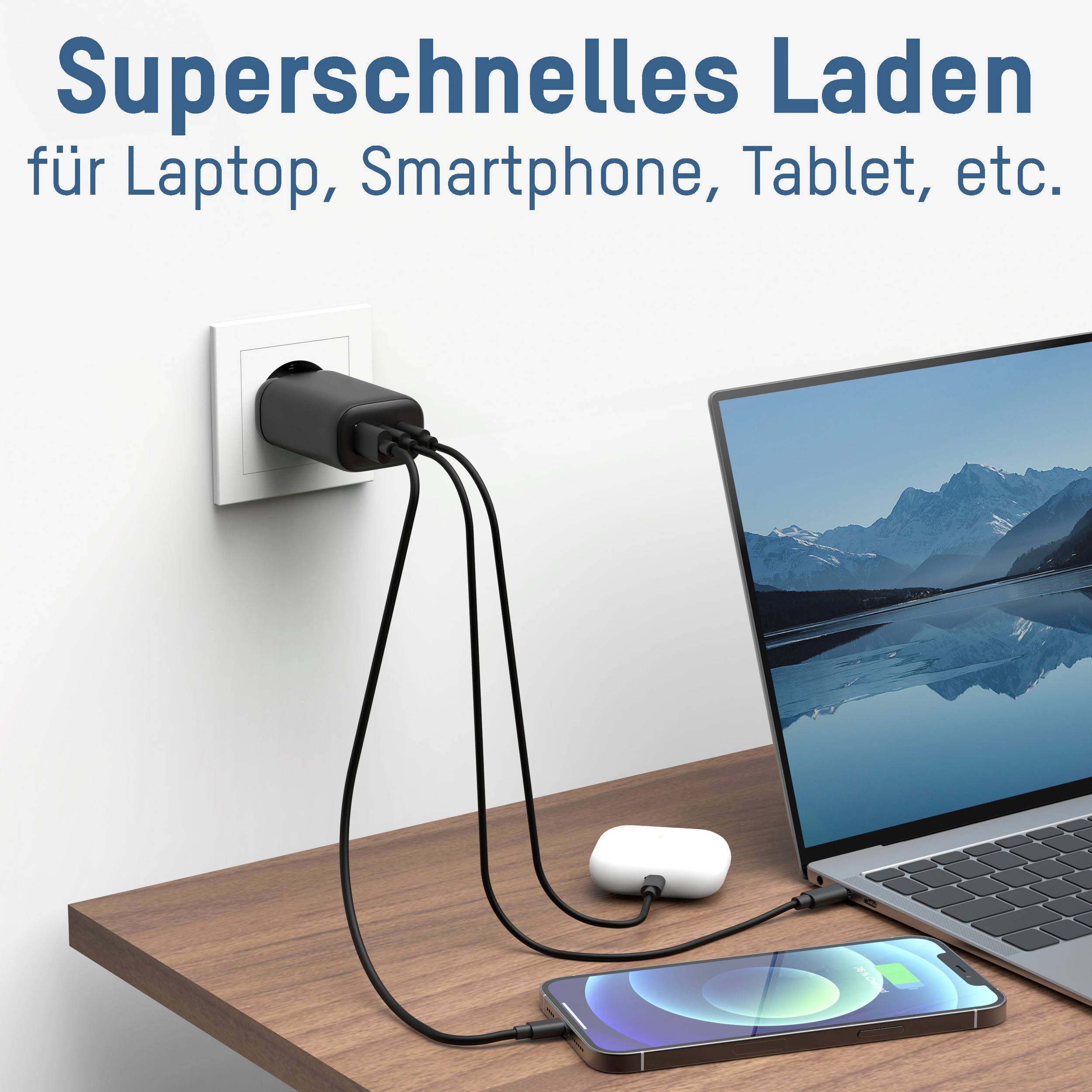 Superschnelles Ladegerät an einer Steckdose, verbunden mit einem Laptop und einem Smartphone auf einem Holztisch.