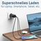 Superschnelles Ladegerät an einer Steckdose, verbunden mit einem Laptop und einem Smartphone auf einem Holztisch.