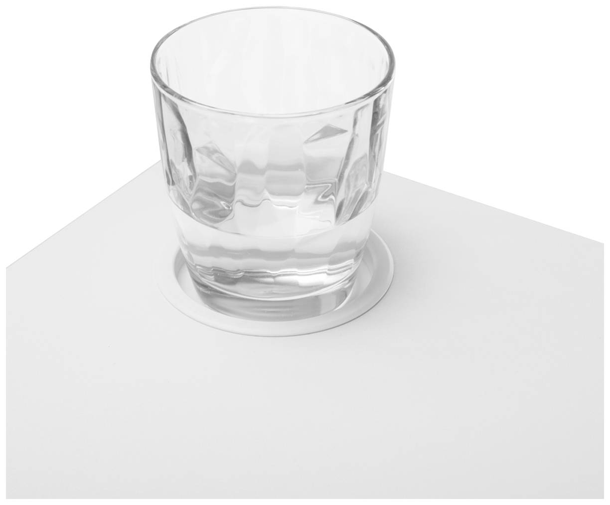 Ein transparentes Glas mit Wasser steht auf einem weißen Tischuntersetzer. Das Glas ist einfach gestaltet und halbvoll.