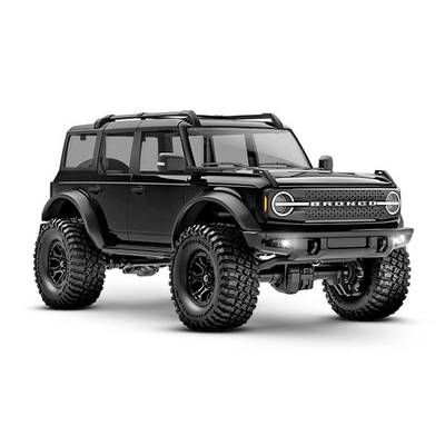 Ein schwarzer Offroad-Geländewagen mit großen Geländereifen und massiven Stoßfängern, fahrbereit und robust gestaltet.