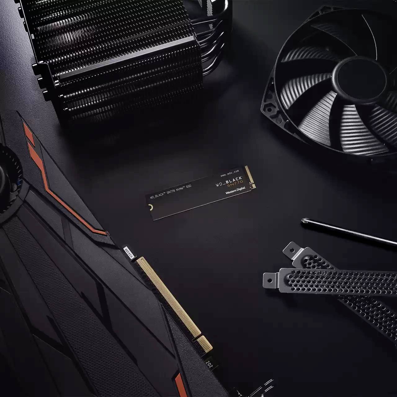 Grafikkarte, Ventilator und SSD auf schwarzem Hintergrund. Elektronikkomponenten mit verschiedenen Kühlmethoden für Computerhardware.