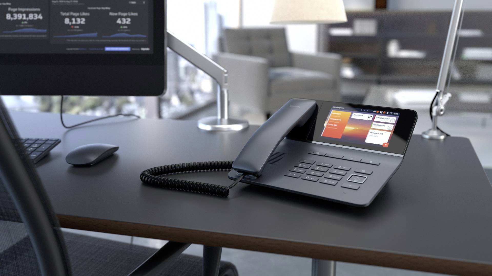Ein schwarzes Tischtelefon mit großem Display steht auf einem modernen Büro-Schreibtisch neben einem Computerbildschirm.
