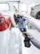 Eine Person poliert die glänzende Oberfläche eines Autos mit einer elektrischen Poliermaschine in einer Autowerkstatt.