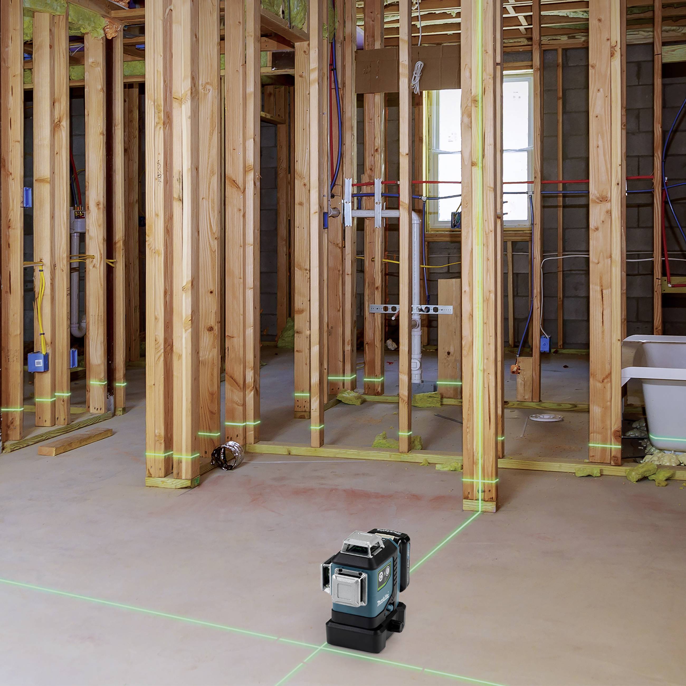 Neubau-Holzrahmenkonstruktion mit sichtbaren elektrischen und sanitären Installationen. Ein Laserwerkzeug ebnet den Boden.