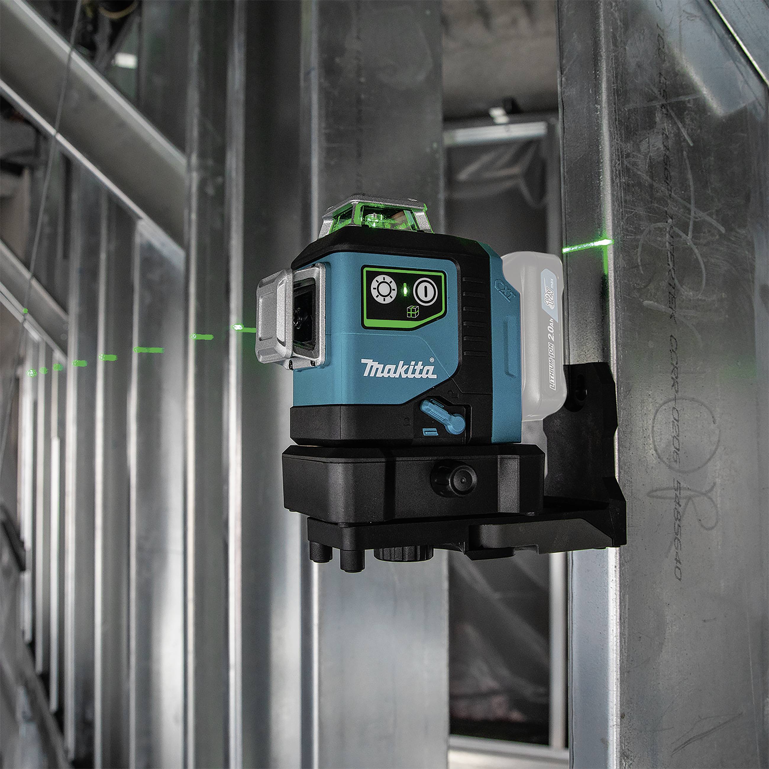 Ein grüner Kreuzlinienlaser befestigt an einem Metallträger in einem Gebäude im Bau. Der Laser projiziert präzise horizontale und vertikale Linien.