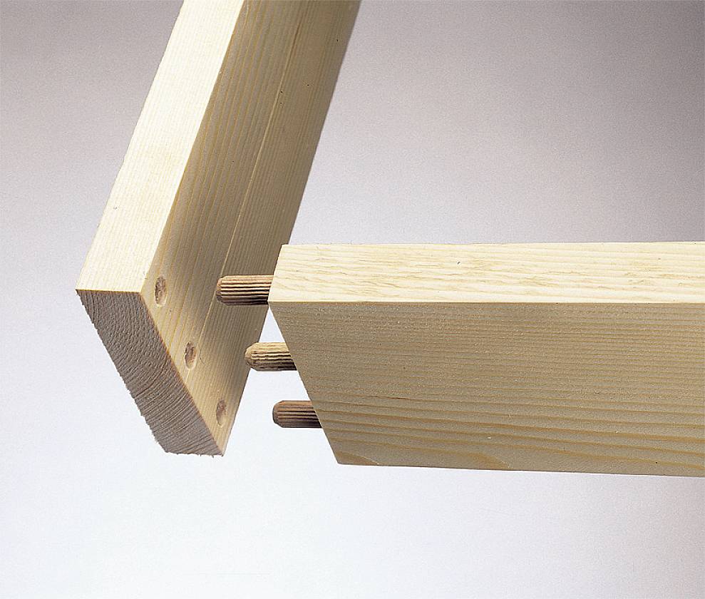 Zwei Holzbretter, die mit Holzdübeln verbunden werden, zeigen den Prozess der Eckverbindung im Möbelbau.